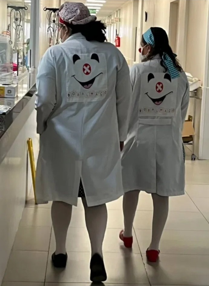 Integrantes da ONG Bobalhaço caminhando em um corredor hospitalar
